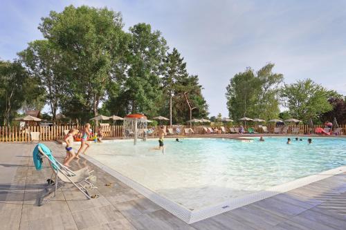 un groupe de personnes jouant dans une piscine dans l'établissement Huttopia Etang Fouché, à Arnay-le-Duc