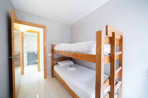 Zimmer mit 2 Etagenbetten und einem Eingang in der Unterkunft Appartement Gran Reserva 9 - WeHostYou in Empuriabrava