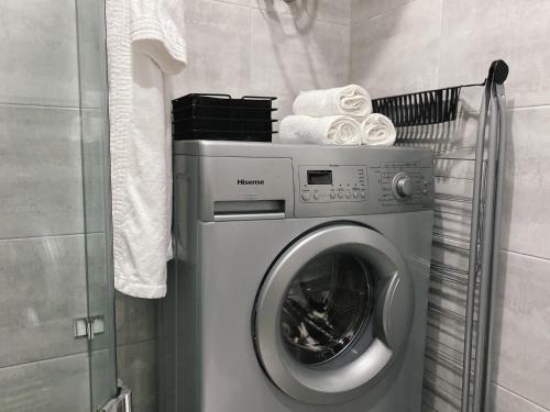 una lavatrice in bagno con asciugamani su un appendiabiti di Seaside Apartment a Batumi