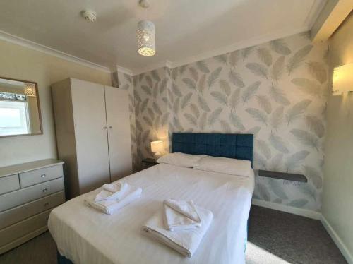 a bedroom with a bed with two towels on it at The Purple Tree Guest House in Torquay