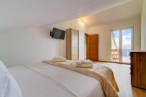a white bedroom with a bed with towels on it at Villa Panorama in Senj