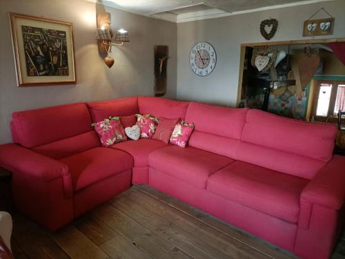 a red couch with pillows in a living room at Maison du Mont in Aosta