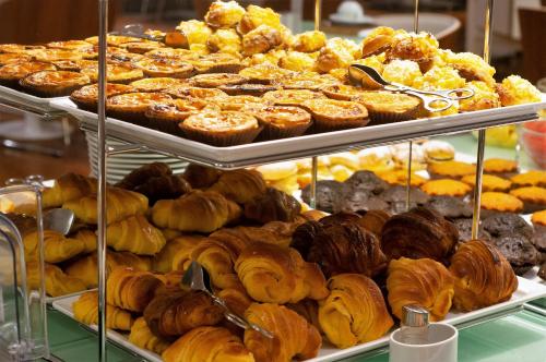 een vitrine gevuld met veel verschillende soorten gebak bij Porto Trindade Hotel in Porto