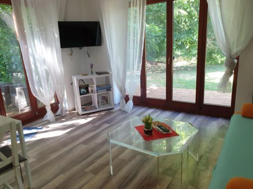 a living room with a glass table and a tv at Ferienwohnung 3 - Gourmetzimmer in Bestensee