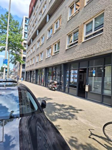 een auto geparkeerd op een straat voor een gebouw bij Beautiful studio 14F in chic neighborhood in center in Rotterdam