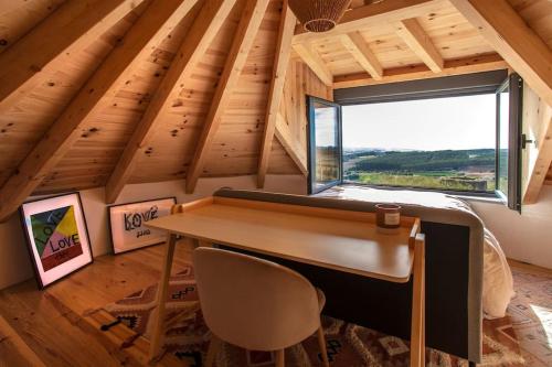 Cette chambre mansardée dispose d'un bureau et d'une fenêtre. dans l'établissement O Moinho 98 - A cozy getaway by the coast, à Lourinhã