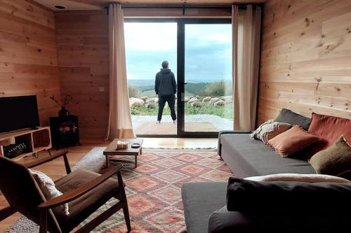 a man looking out the window of a living room at O Moinho 98 - A cozy getaway by the coast in Lourinhã