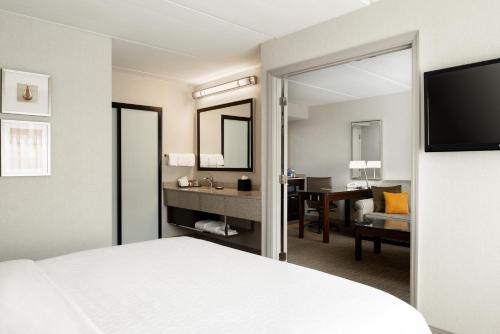 a hotel room with a bed and a mirror at Sheraton Suites Orlando Airport Hotel in Orlando