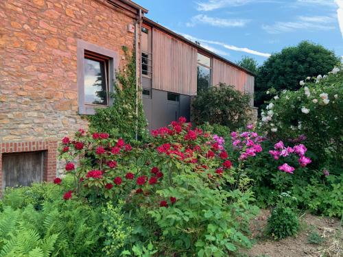 a garden of flowers in front of a brick building at Gîte Banet-Sart à Daverdisse in Daverdisse