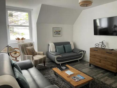 a living room with a couch and a table at The Holiday Hoose in Kinghorn