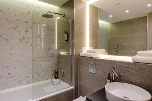 a bathroom with a shower and a toilet and a sink at Charles Hope London Brentford in Brentford