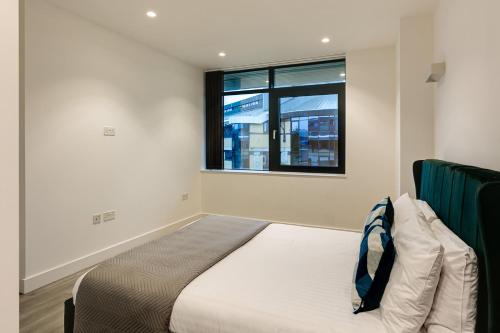 a bedroom with a bed and a window at Charles Hope London Brentford in Brentford