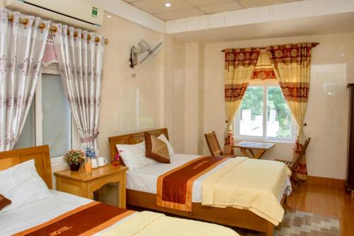 1 dormitorio con 2 camas y ventana en HOA PHUONG PHONG NHA Hotel en Phong Nha