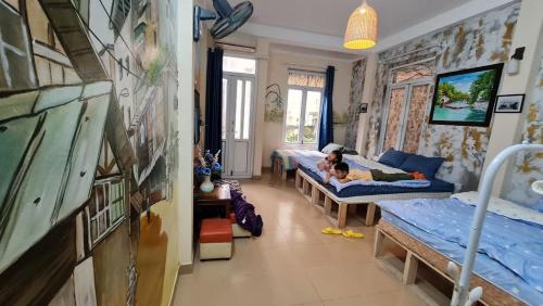 dziecko leżące na łóżku w pokoju z dwoma łóżkami w obiekcie H2 homestay phố cổ check in tự động w mieście Hanoi