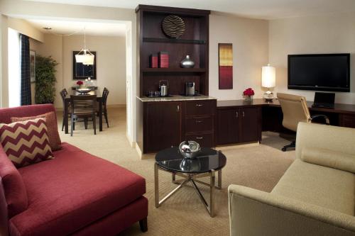 Sheraton Albuquerque Uptown by Marriott في ألباكيركي: غرفة معيشة مع أريكة وطاولة