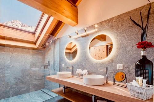 a bathroom with two sinks and a large mirror at Hotel Waldhaus am See in Valbella