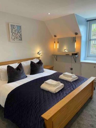 a bedroom with a large bed with two towels on it at The Holiday Hoose in Kinghorn
