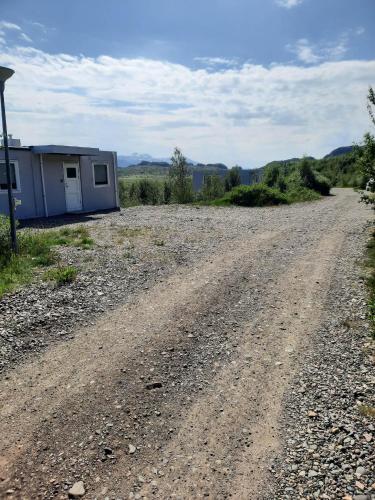 a dirt road in front of a small building at Vinland Apartment 1 in Egilsstaðir