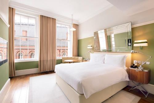 ロンドンにあるグレート ノーザン ホテル ア トリビュート ポートフォリオ ホテル ロンドンの大きなベッドと窓が備わるホテルルームです。