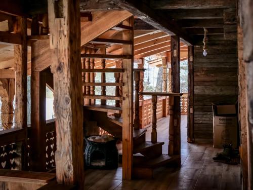 a staircase in a cabin with wooden walls and wood floors at Hanu lu’ Vasile in Breb