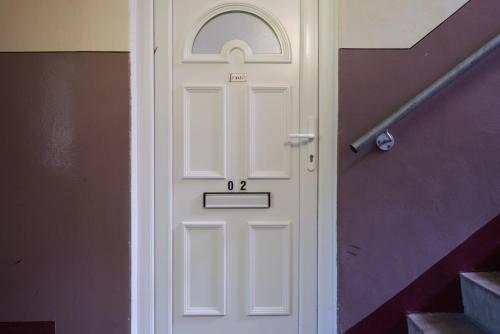 a white door with a window in a building at Rotherwood Apartment in Glasgow