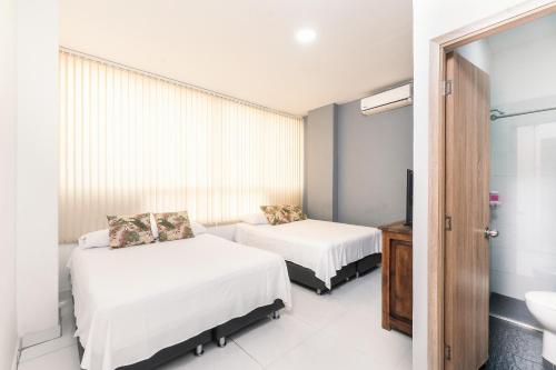 a hotel room with two beds and a sink at Hotel París in Villeta