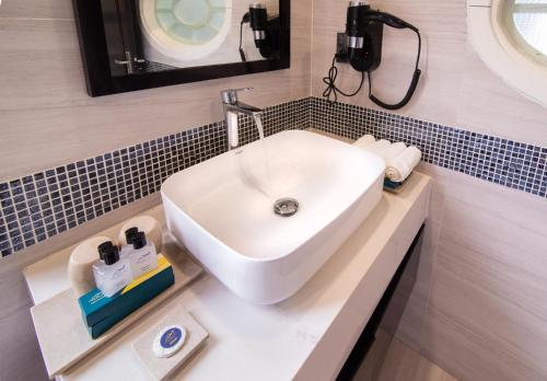 a bathroom with a white sink and a mirror at Minh Chau Pearl Hotel & Spa - Quan Lan Island in Quang Ninh