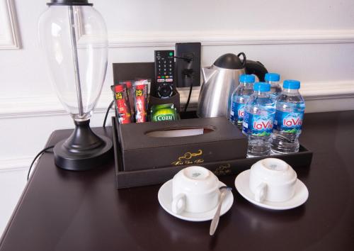 a black table with a bottle of water and two white plates at Minh Chau Pearl Hotel & Spa - Quan Lan Island in Quang Ninh