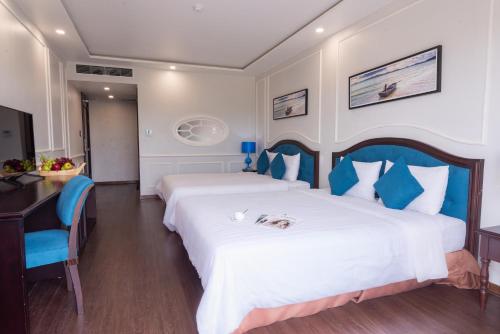 une chambre d'hôtel avec 2 lits avec un chien sur le lit dans l'établissement Minh Chau Pearl Hotel & Spa - Quan Lan Island, à Quảng Ninh