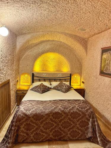 a bedroom with a large bed in a stone room at Takaev Cave House in Uchisar