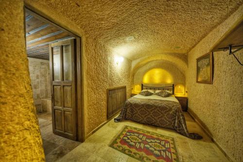 a bedroom with a bed and an open door at Takaev Cave House in Uchisar