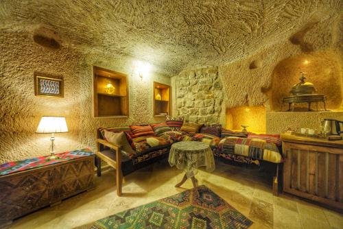 a living room with couches and a stone wall at Takaev Cave House in Uchisar