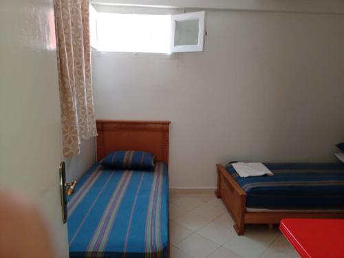 a small bedroom with two beds and a window at KHAOULA in Rabat