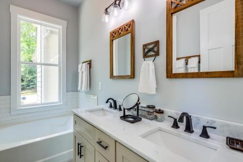 a bathroom with a sink and a mirror and a tub at Quaint Newnan Vacation Rental Near State Park! in Newnan