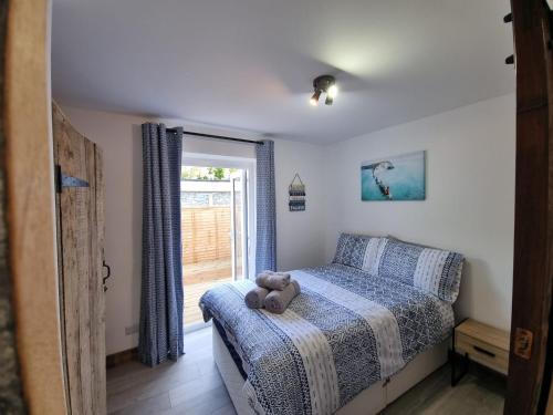 un osito de peluche sentado en una cama en un dormitorio en The Wight House B&B, en Ryde