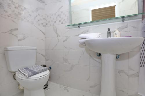 een witte badkamer met een toilet en een wastafel bij House of town in Skopelos Town