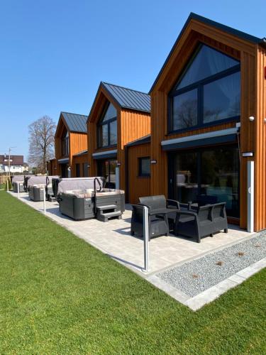 a building with a patio with couches and tables at Apartamenty MarMar in Sławoszynko