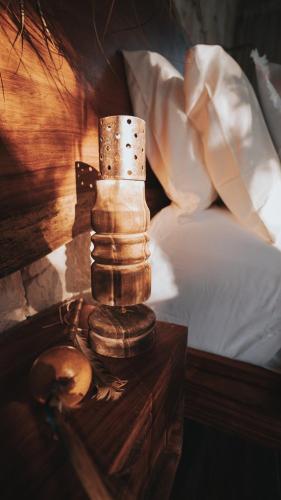 a stack of wooden bracelets on a table next to a bed at Kaaba Luum Jungle Villas in Chemuyil