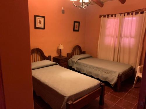 a bedroom with two beds and a chandelier at La casa de Mamina in Tilcara