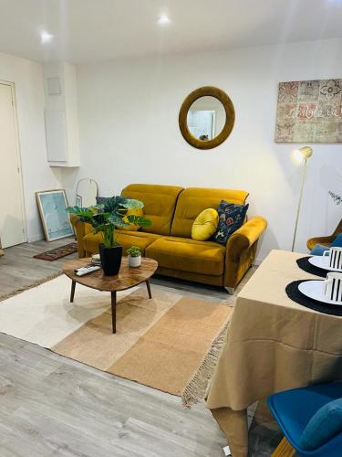 a living room with a yellow couch and a table at studio cosy Vieux-Nice in Nice