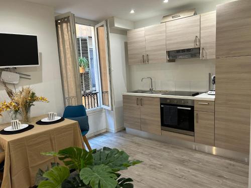 a kitchen with wooden cabinets and a table and a dining room at studio cosy Vieux-Nice in Nice