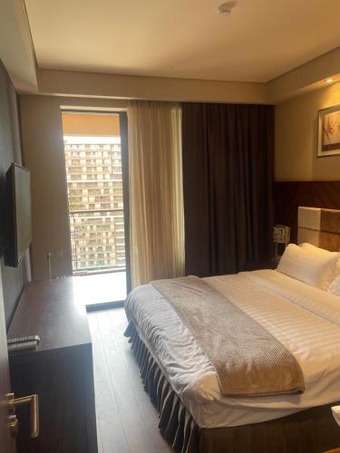a hotel room with a bed and a window at Dreamland Oasis Chakvi apartment 1406 in Chakvi