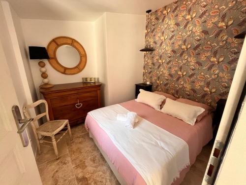 a small bedroom with a bed and a mirror at Petite maison cosy in Six-Fours-les-Plages