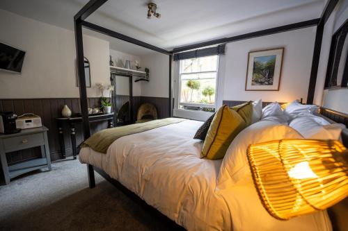 a bedroom with a large bed with yellow pillows at The Griffin Inn Bath in Bath