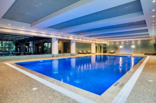 a large swimming pool in a hotel with blue water at Al Ahsa InterContinental by IHG in Al Ahsa