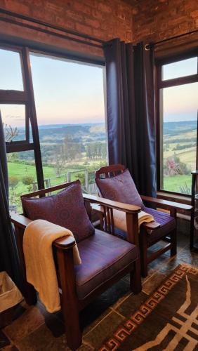 a room with two chairs and large windows at THE VIEWPOINT SUV vehicle required in Howick