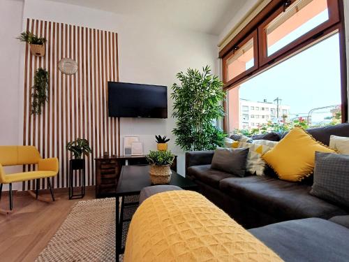 a living room with a couch and a tv at LOFT de Tita Larrea in Arriondas