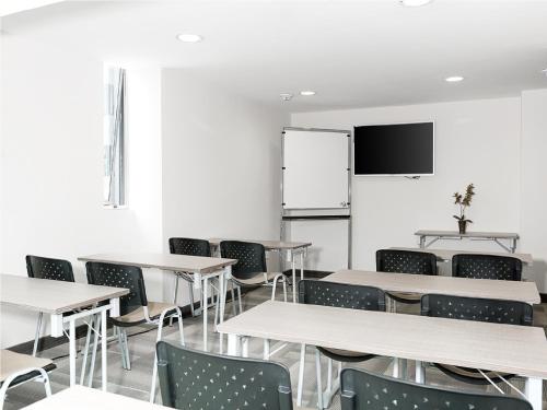 a classroom with tables and chairs and a tv at Hotel bh Usaquén in Bogotá