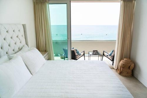 a bedroom with a large bed with a view of the ocean at Hotel Suite Luxe Sunset in Tijuana