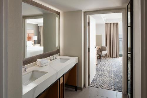 a bathroom with a sink and a large mirror at Sheraton Oceanfront Hotel in Virginia Beach